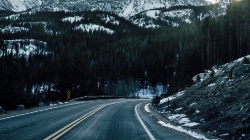 Driving through mountains covered in snow HD Wallpaper