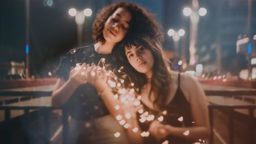 Two Women Holding String Lights Turned on HD Wallpaper